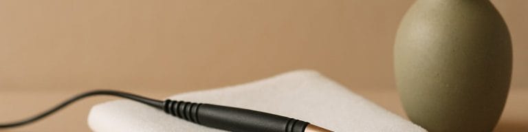 Ultra-fine probe on folded white linen, beige backdrop. Electrolysis hair removal. Skincare & Waxing Kirkham.