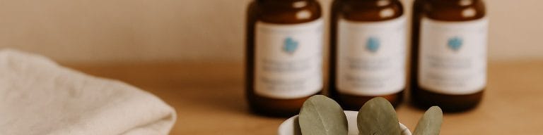 Amber skincare jars, eucalyptus bowl, muslin on wood. Bespoke facial treatment. Skincare & Waxing Kirkham.
